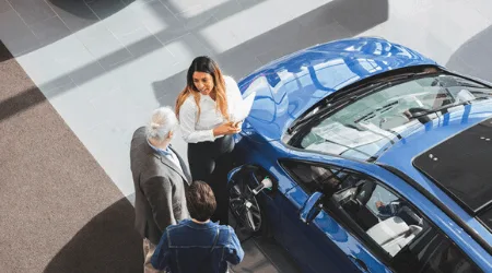 Image: Getty Images sales person and customers talking about a car