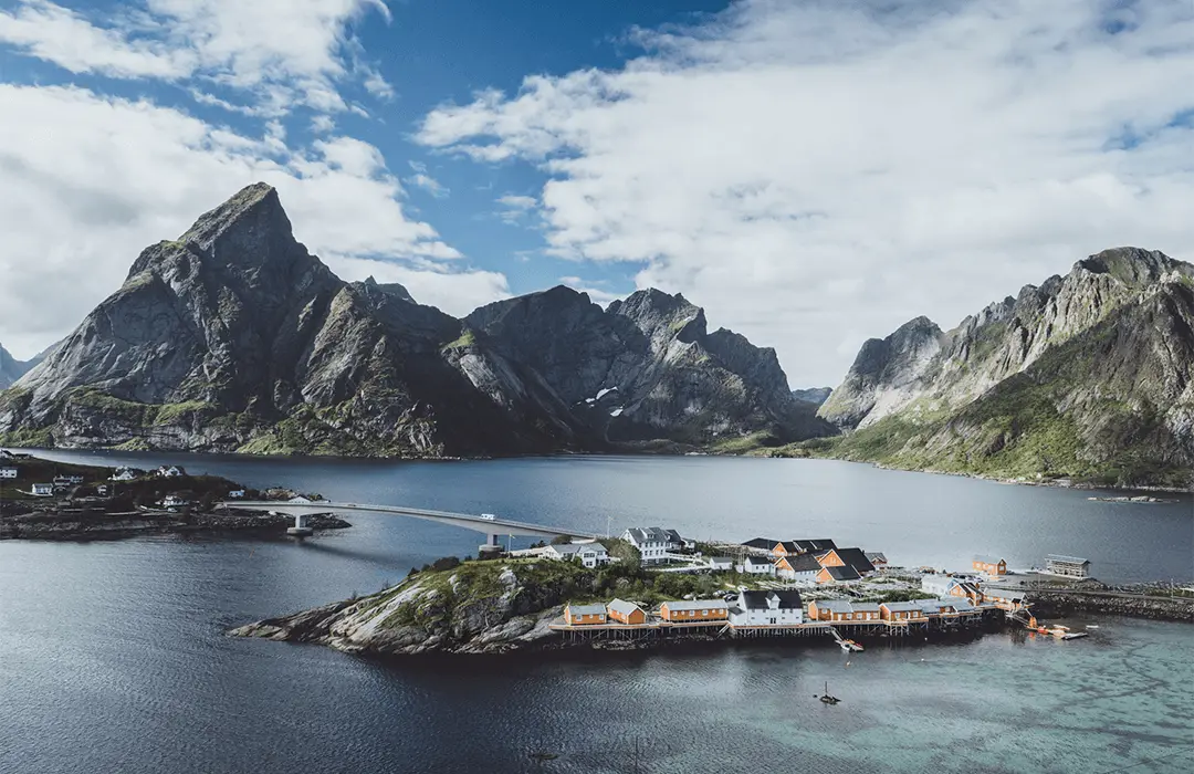 Image: Getty Images Beautiful summer landscape panorama with yellow wooden traditional houses on the sea near mountain range in background, Lofoten Islands, Norway