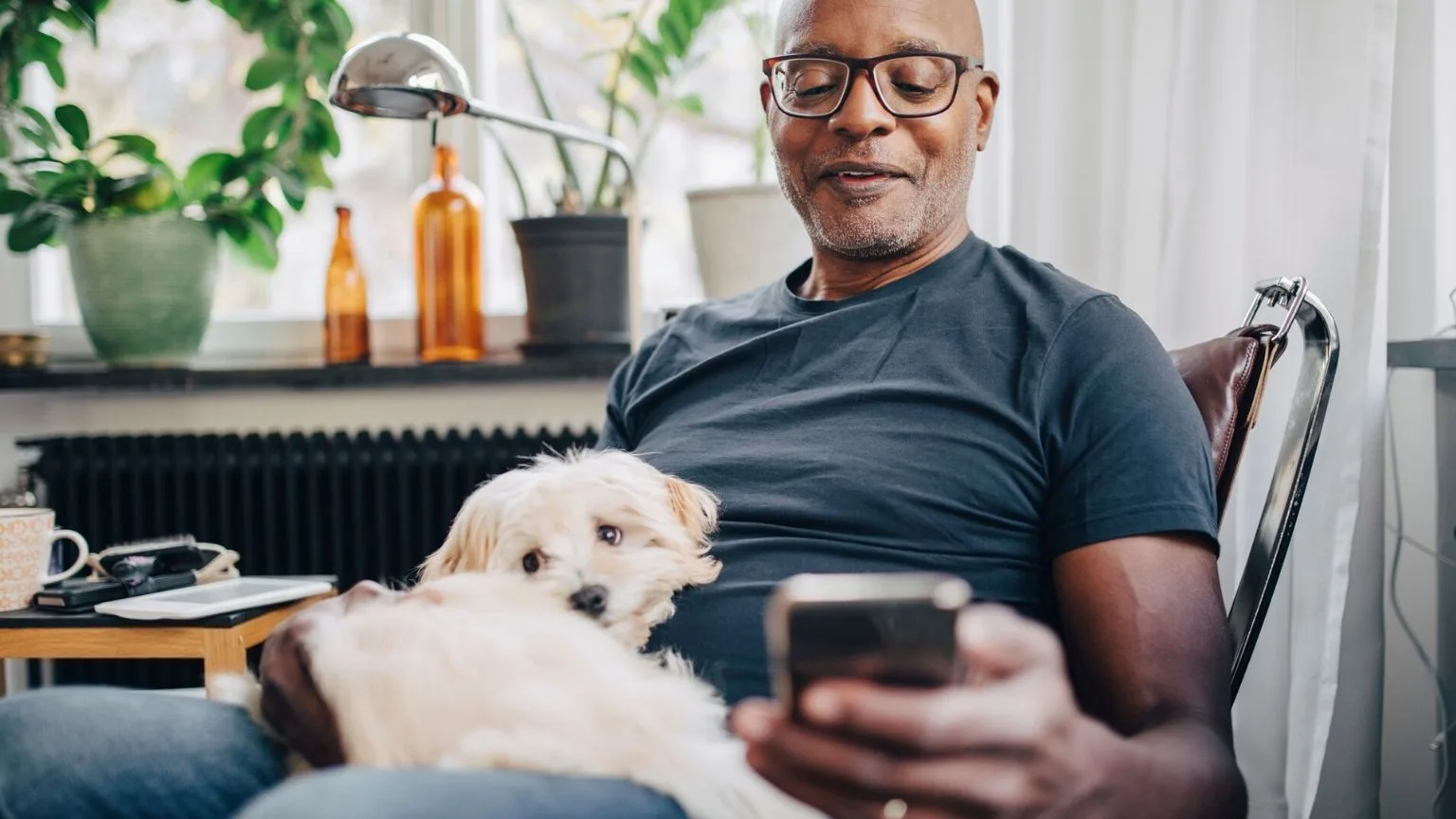 Image: Getty Images Man with his dog and smartphone in his hand