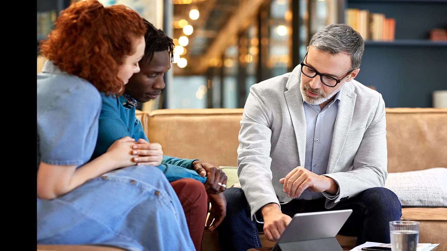 Image: Getty Images Couple chatting with a business man in front a computer