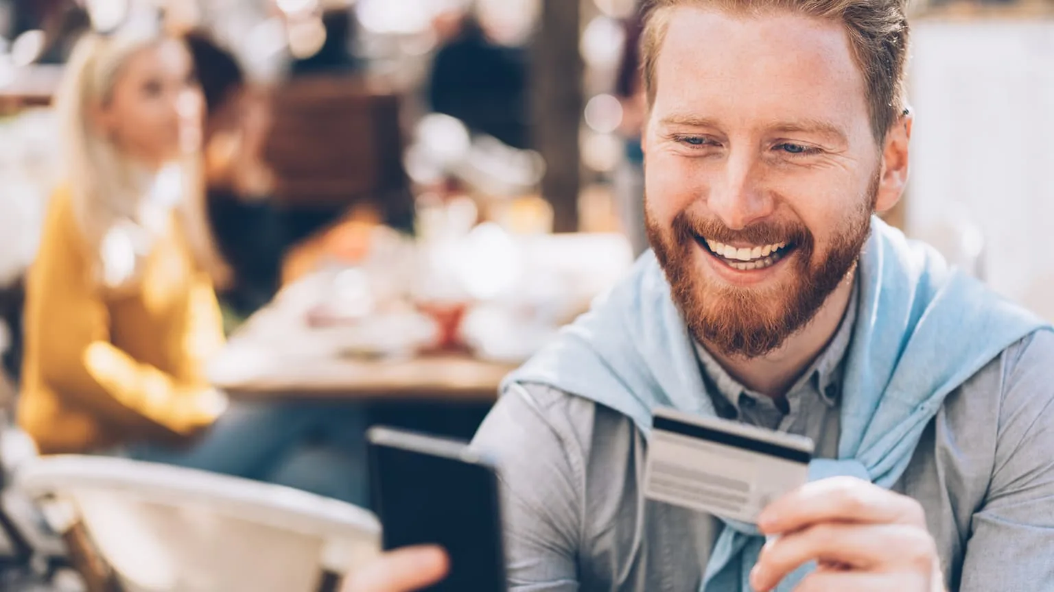 Image: Getty Images Young man online banking outdoor in cafe