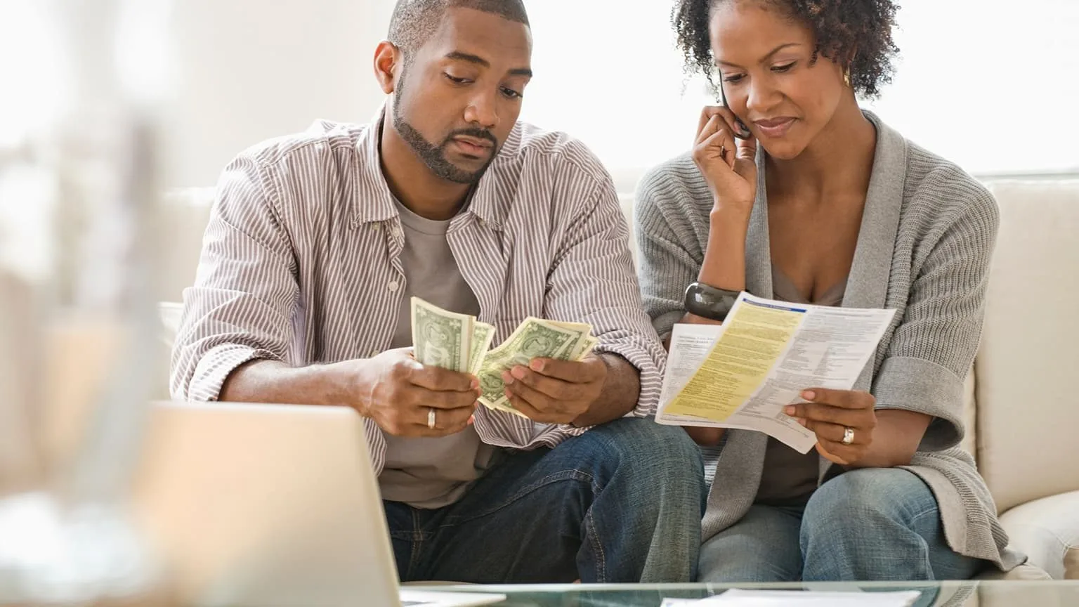 Image: Getty Images Couple paying bills, woman talking on the phone with utility company