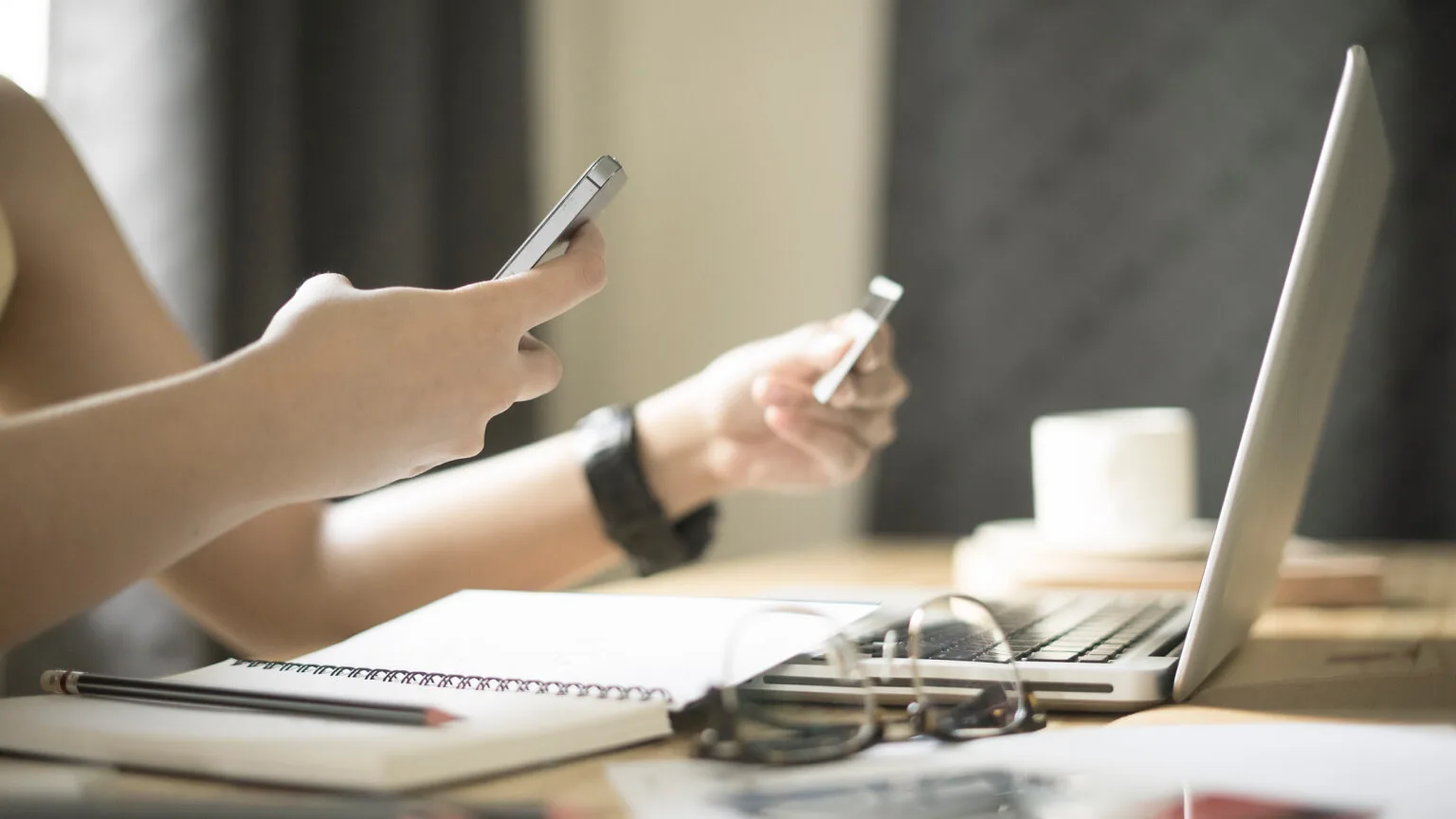 Image: Getty Images person at the computer with their phone and credit card
