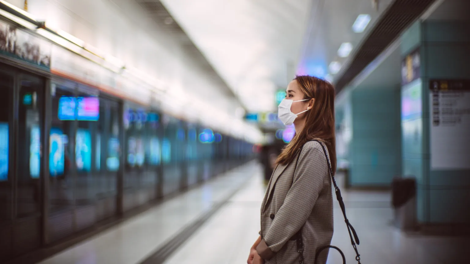 Image: Getty Images woman standing in the airport with a mask on