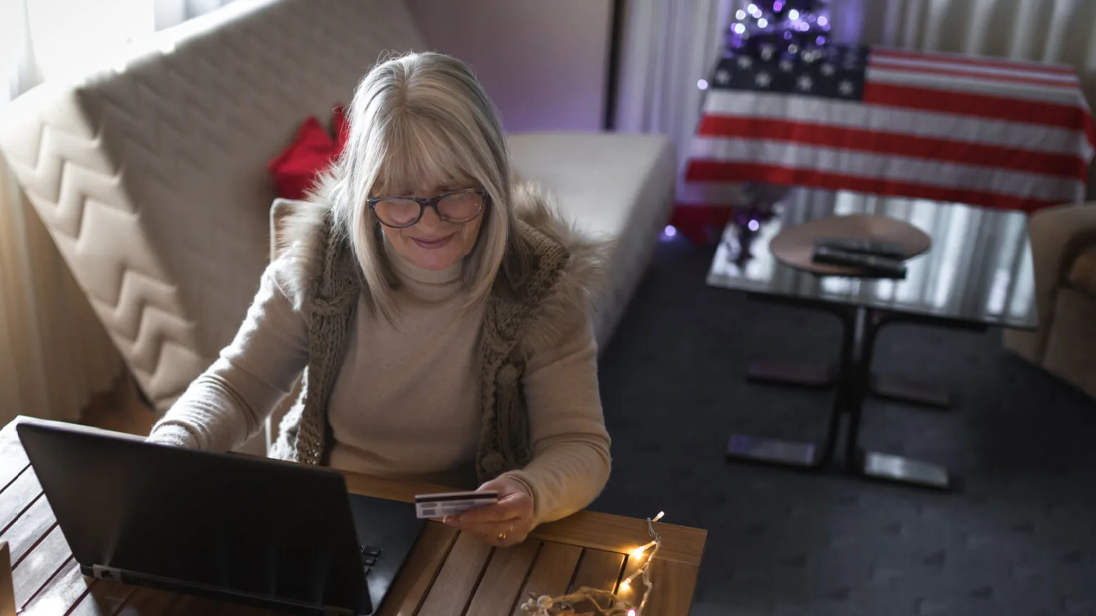 Image: Getty Images woman making a donation on her laptop with an american flag in the background