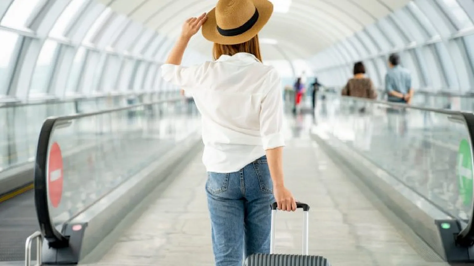 Image: Getty Images Traveler walking through airport with suitcase