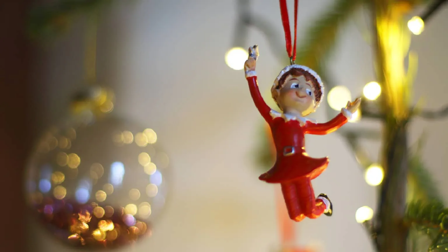 Created in PicMonkey an elf on the shelf ornament hanging on a Christmas tree