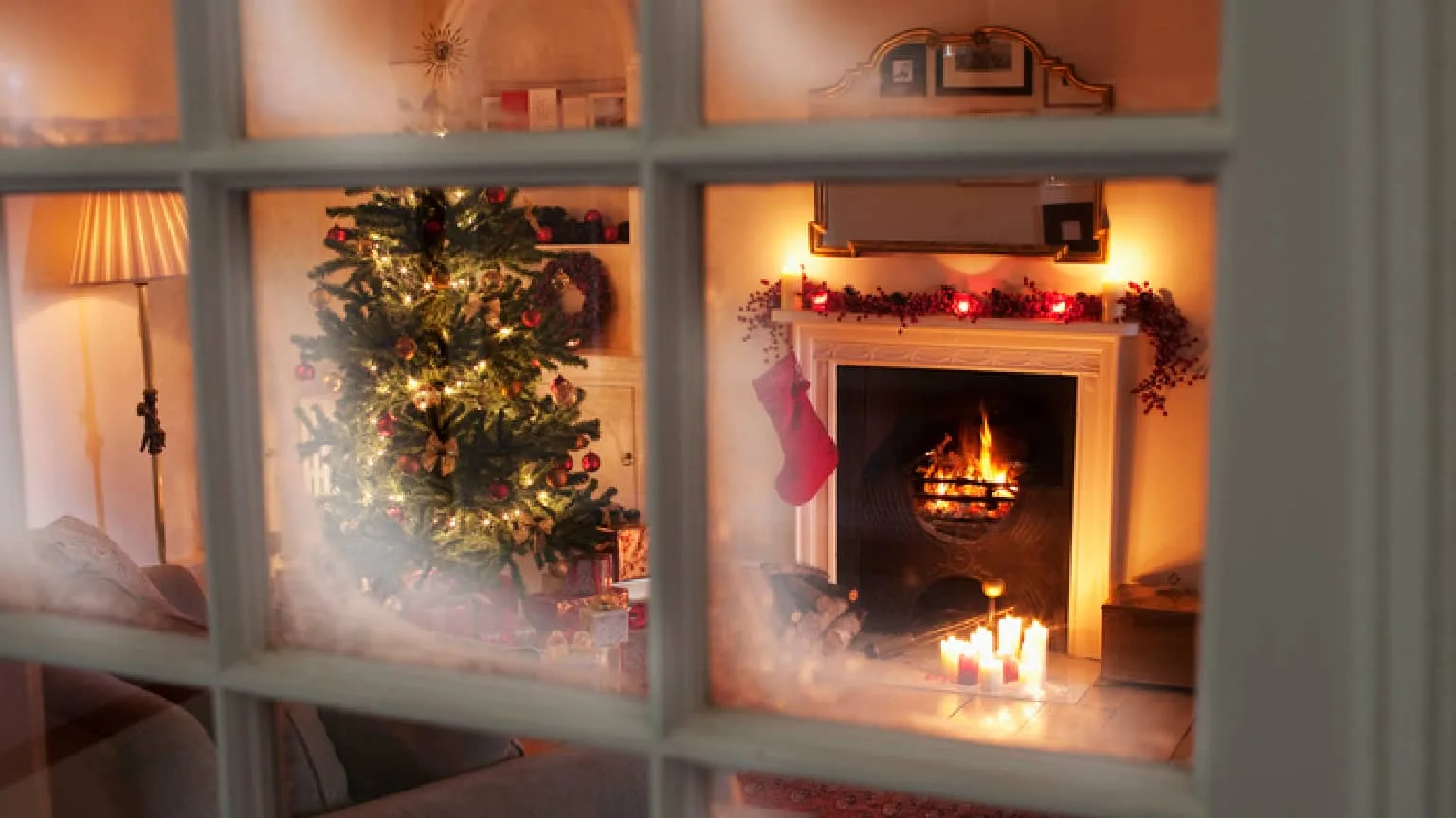 Image: Getty Images a home decorated for Christmas with a fireplace lit