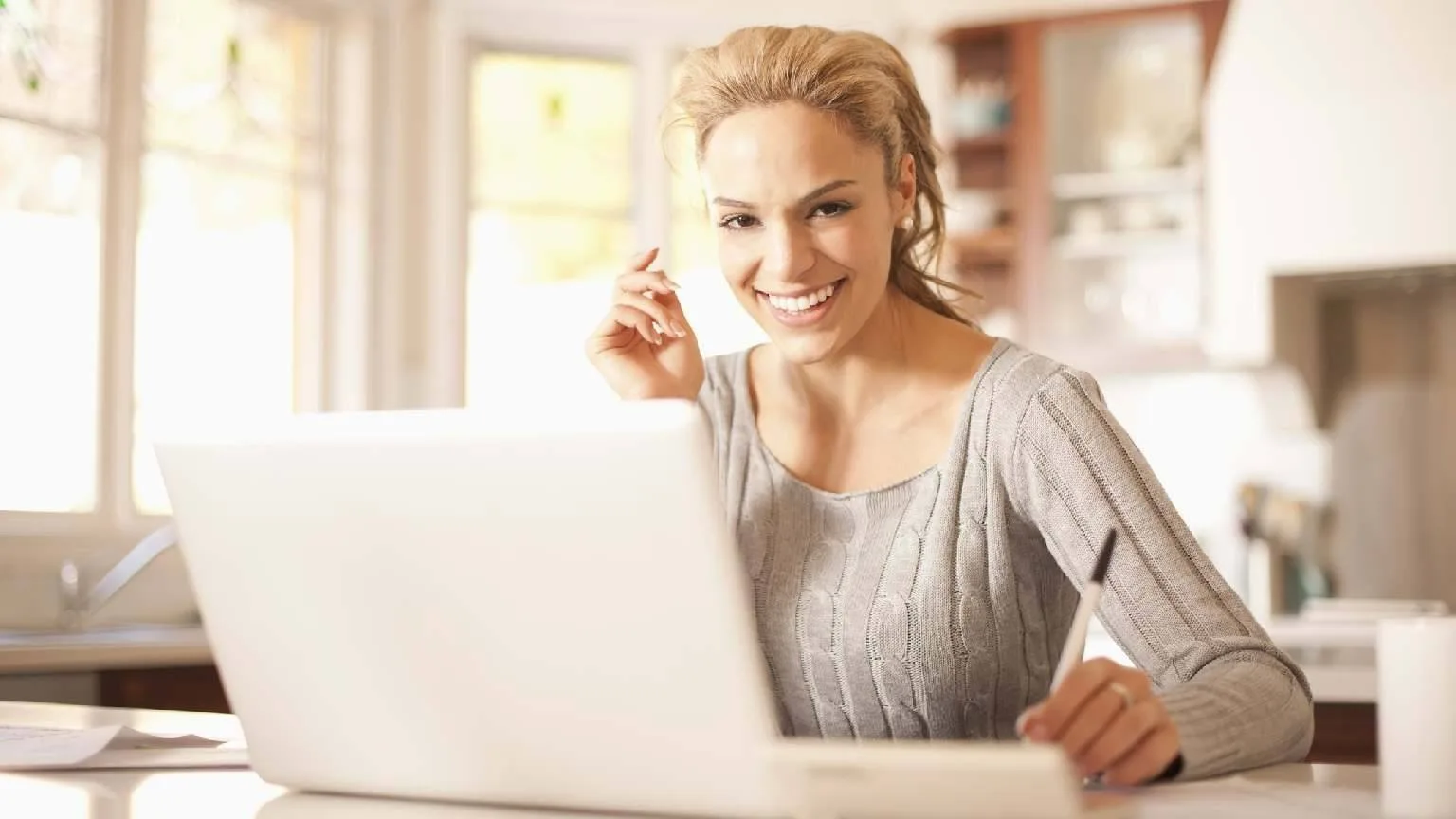 Image: Getty Images woman smiling using a laptop