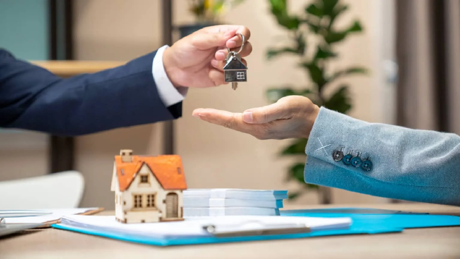 Image: Getty Images a person handing someone else keys to a home