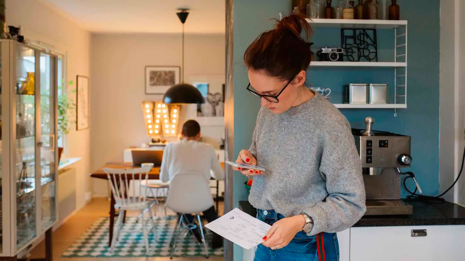Image: Supplied Woman paying bills in kitchen