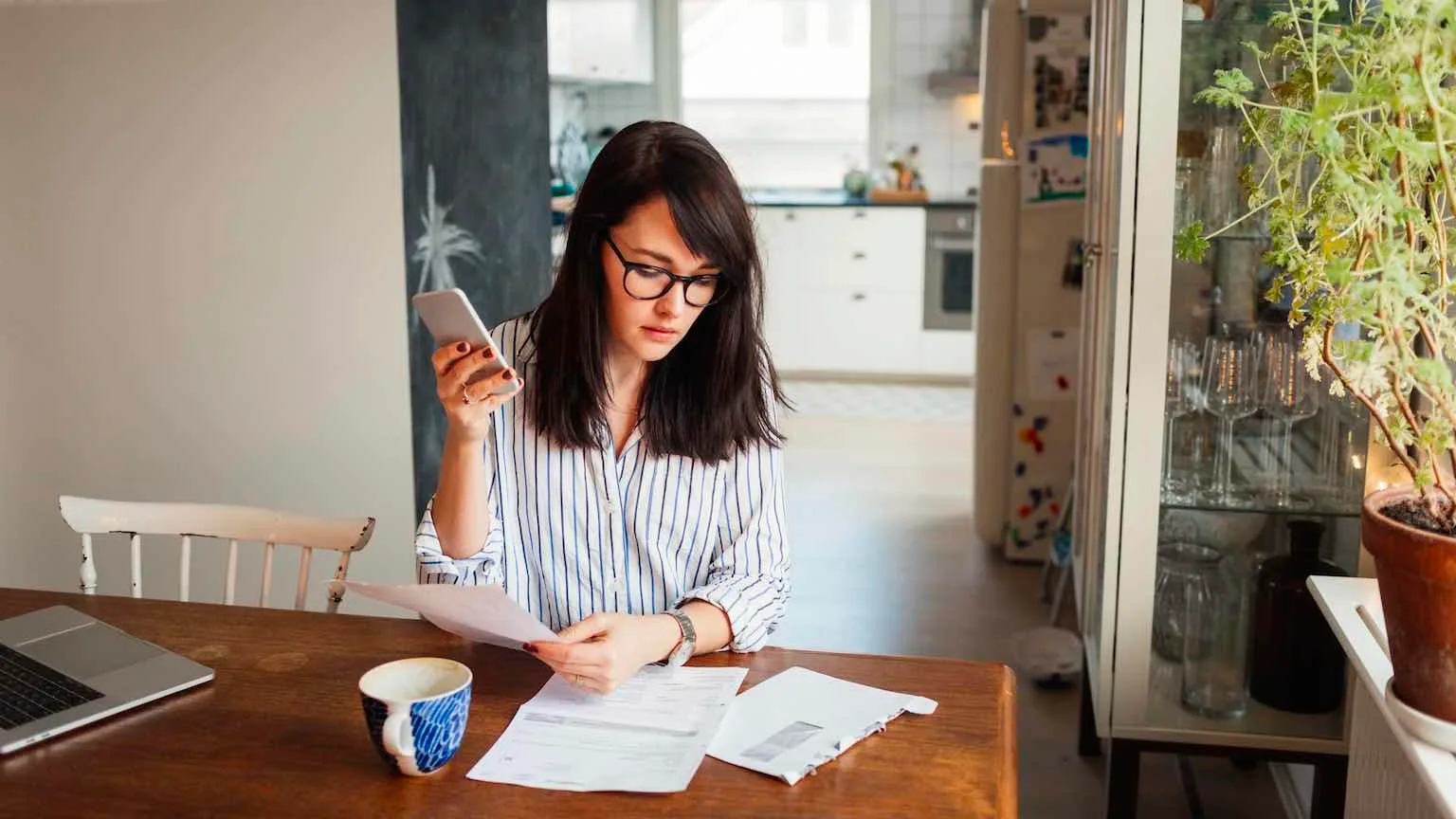 Image: Getty Images Woman paying bills