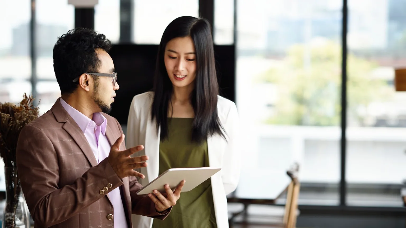 Image: Getty Images Young woman speaks to a man in an office.