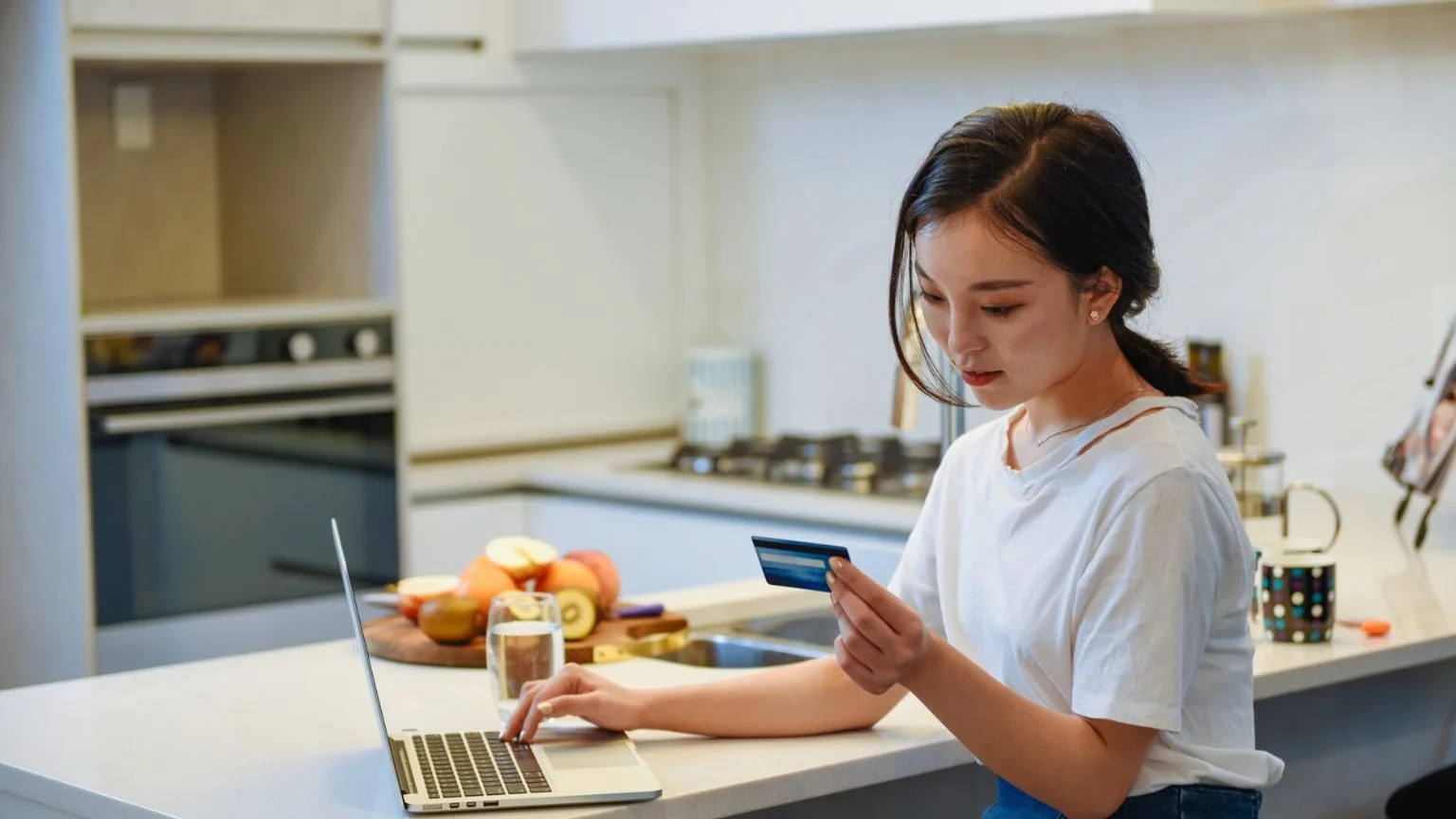 Image: Getty Images Young woman making purchase using a credit card