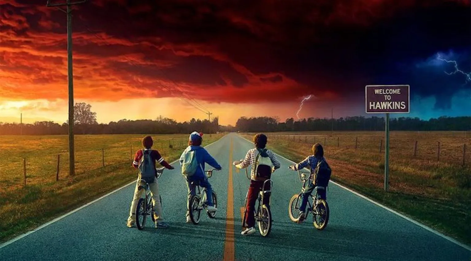 Stranger Things characters riding bicycles on a road looking at a sunset