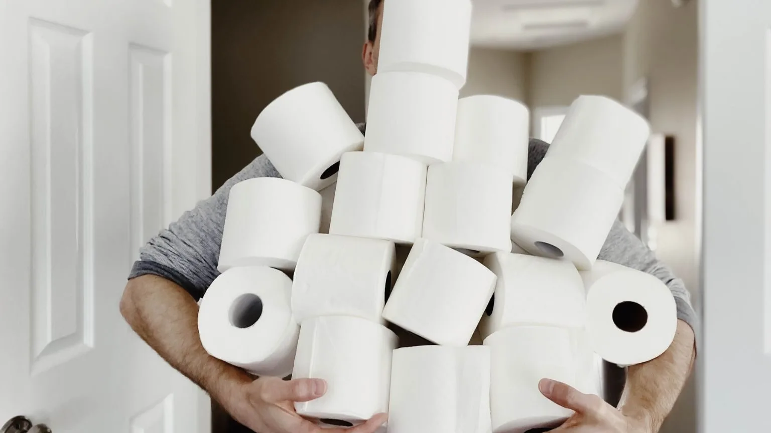 Image: Getty Images Man holding a pile of toilet paper rolls