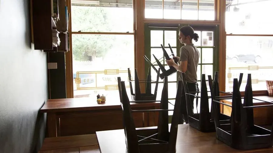 Image: Getty Images Waiter packing away chairs