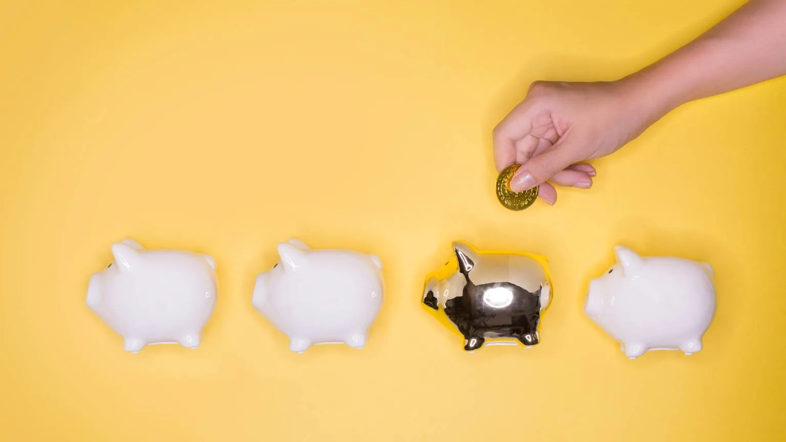 Image: Getty Images Putting a coin into a gold piggy bank