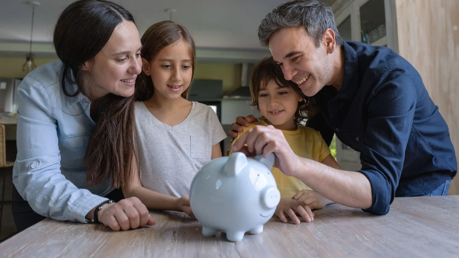 Image: Getty Images Couple teaching kids how to save money