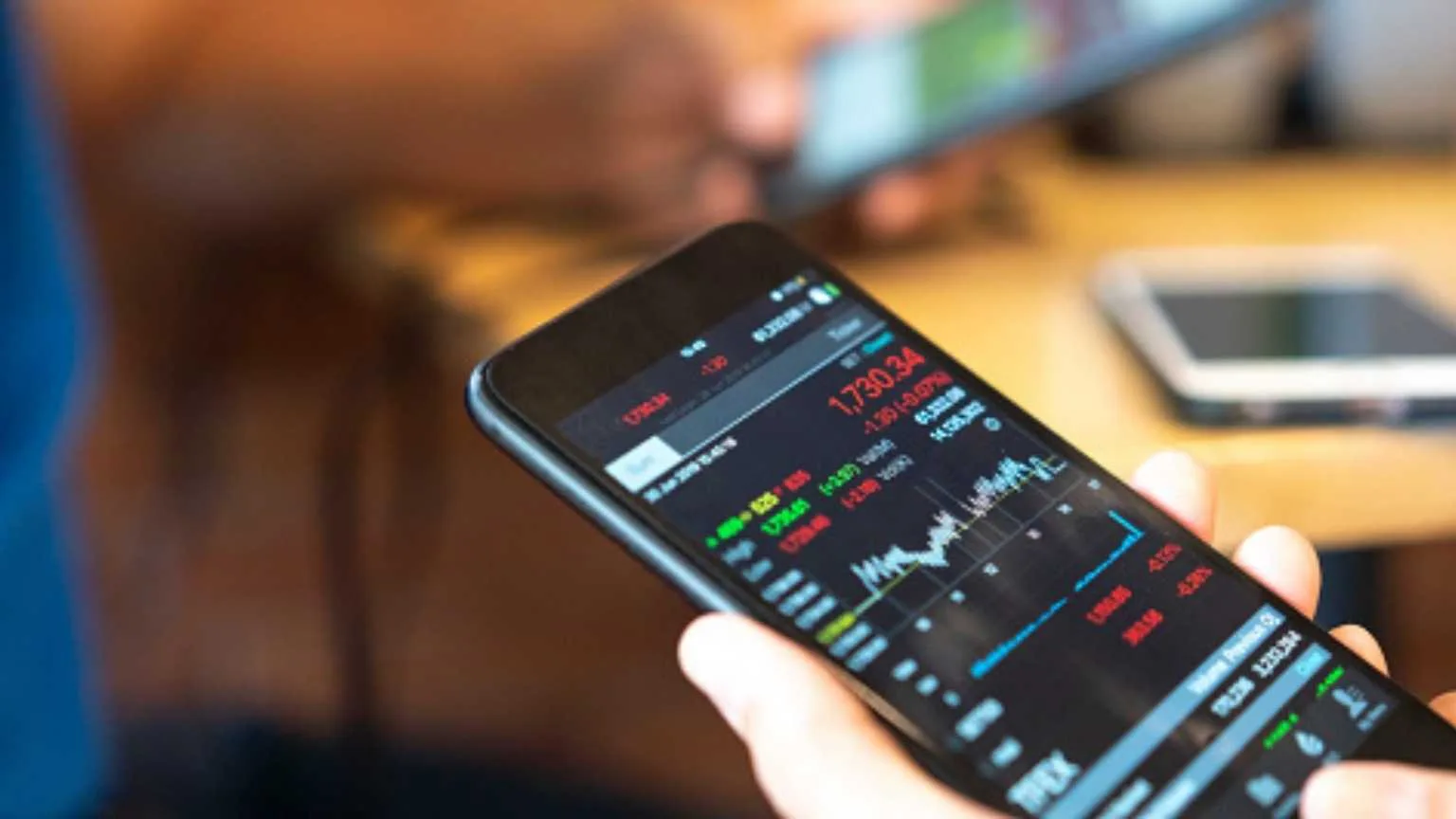 Image: Getty Images Checking share prices using phone