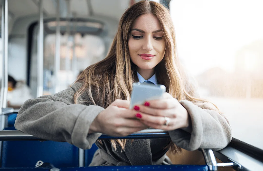 Image: Supplied Lady sitting on a city bus looking at a smartphone