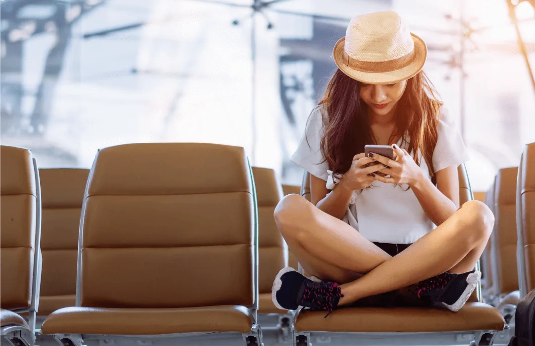 Image: Supplied Lady sitting in airport lounge using phone