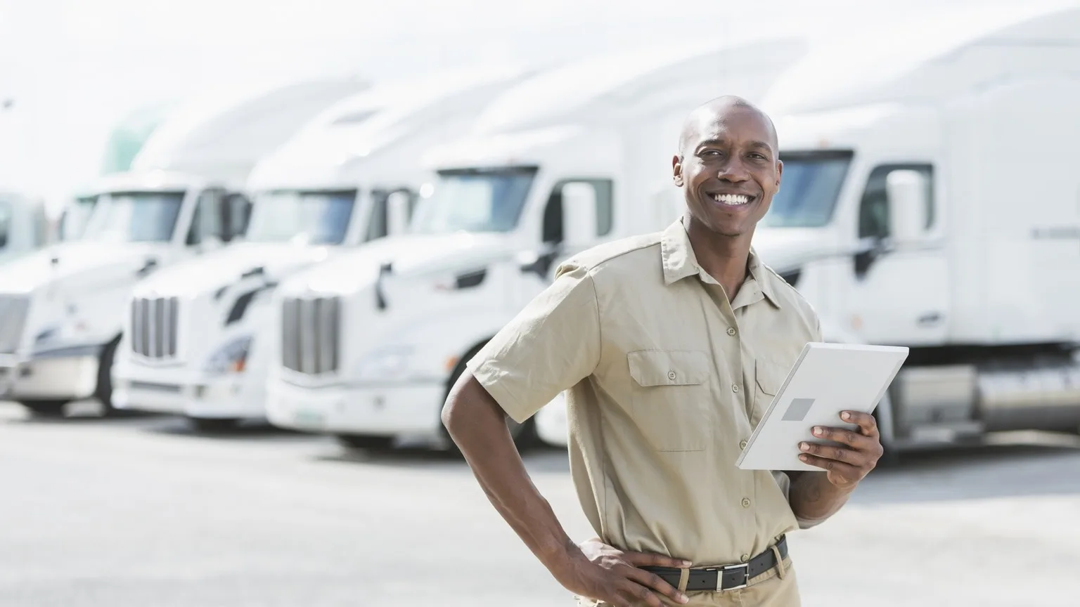 Image: Getty Images Businessman standing in front of fleet of vehicles