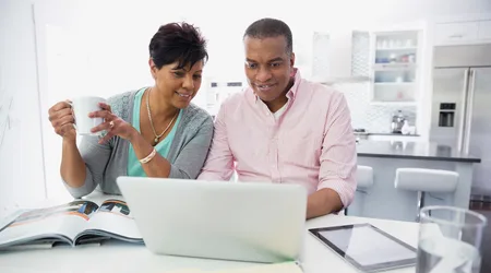 Image: Getty Images A mature couple looking over loan options online