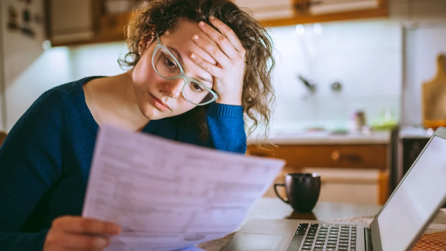 Image: Getty Images Stressed woman looking at her bills