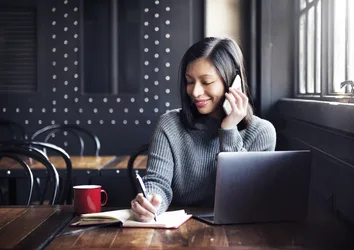 Woman in a coffee shop making a phone call