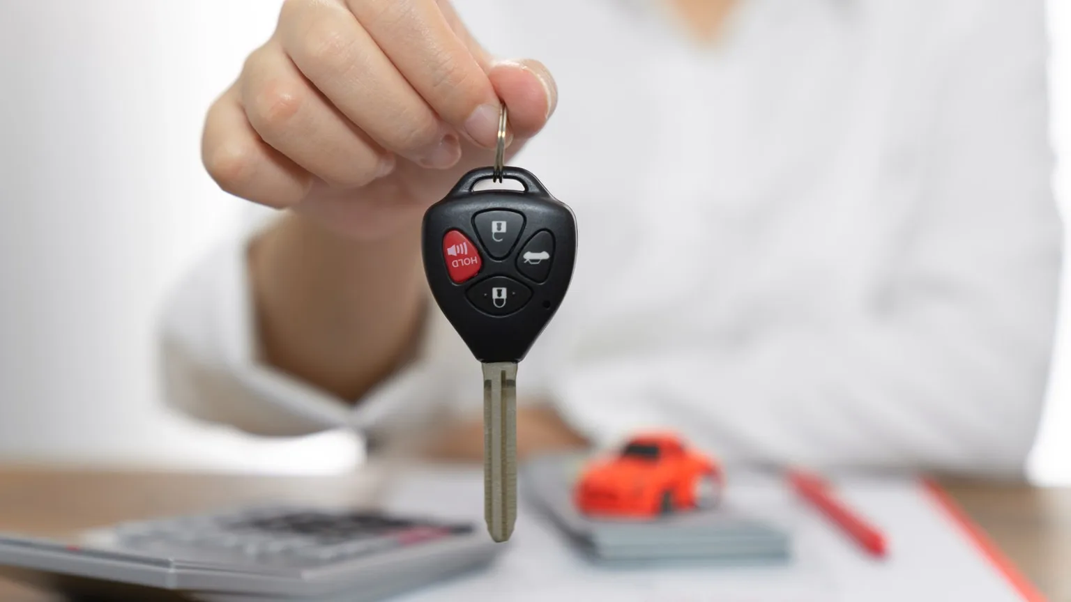 Image: Getty Images Women holding car keys, car loan concept