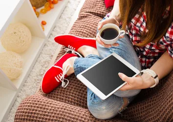 Woman lounging on a couch drinking coffee