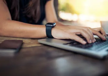 Closeup of woman's hand typing on a laptop