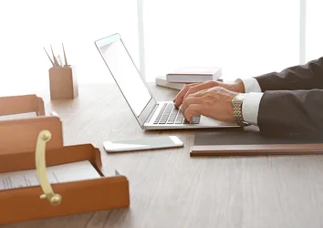 Closeup of a businessman typing on a laptop