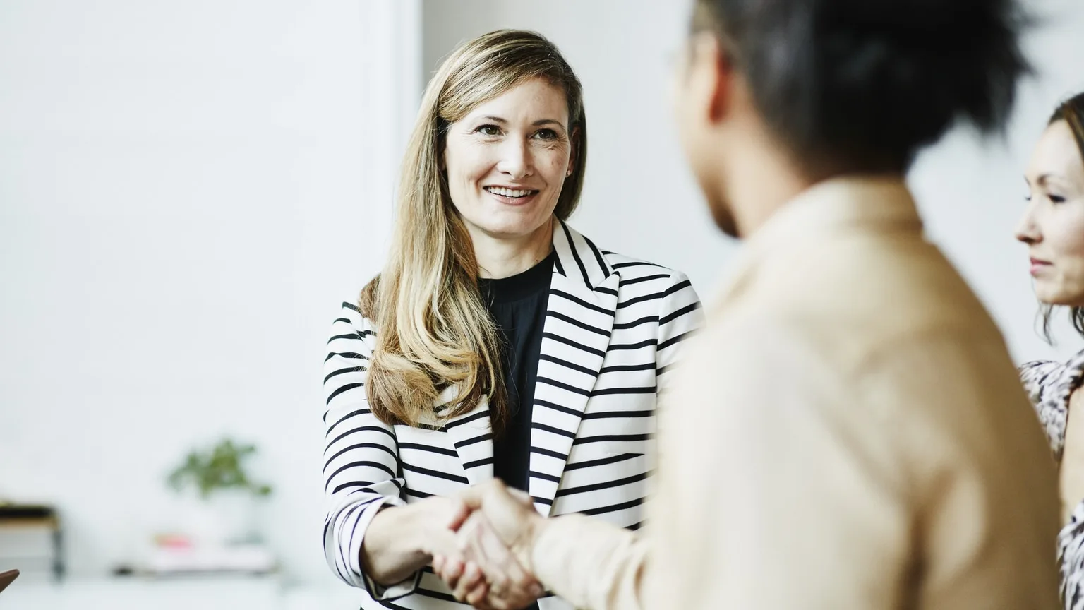 Image: Getty Images Businesswoman shaking hands with financial advisor