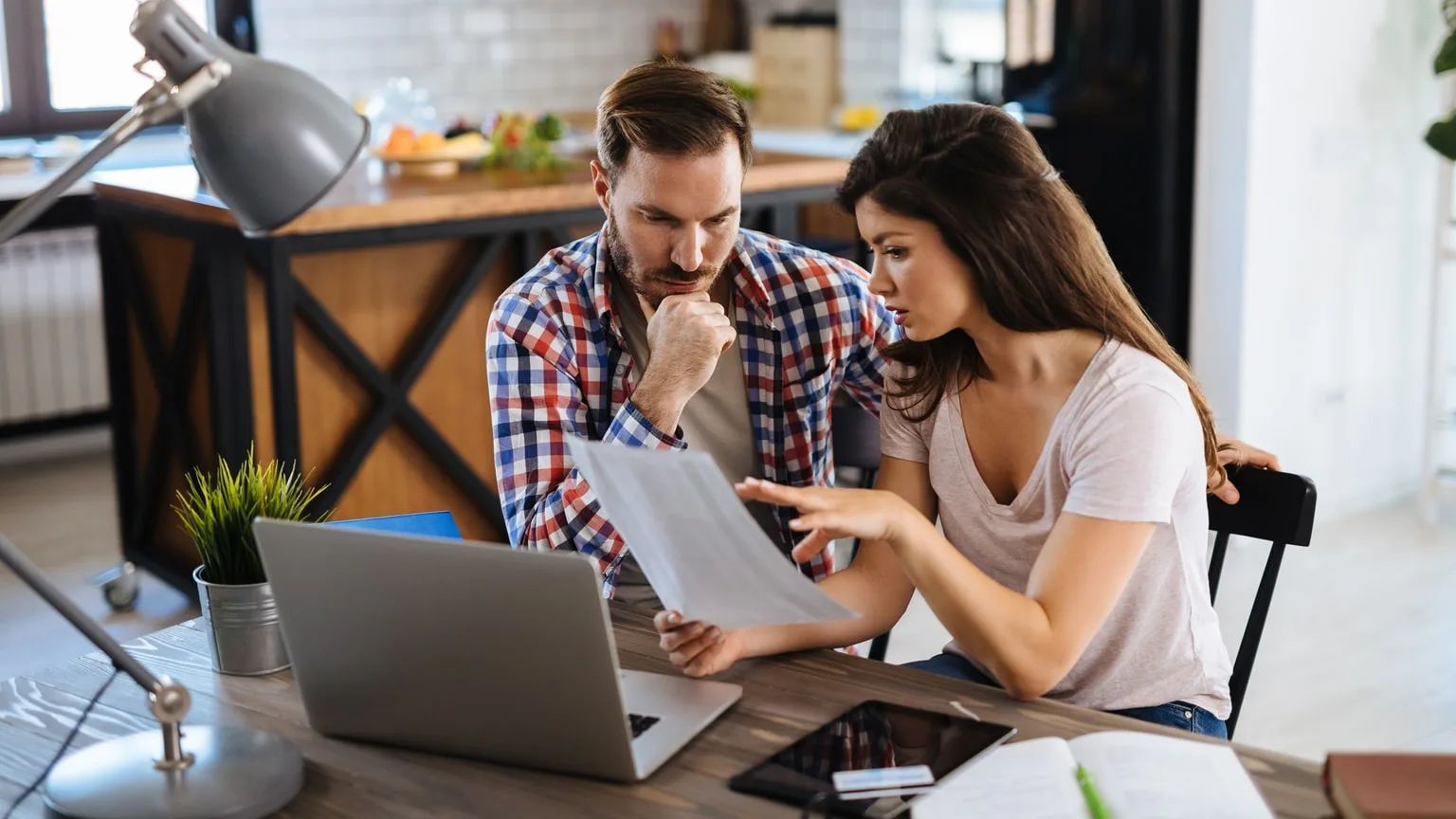 Image: Getty Images Frustrated couple checking finances at home on laptop