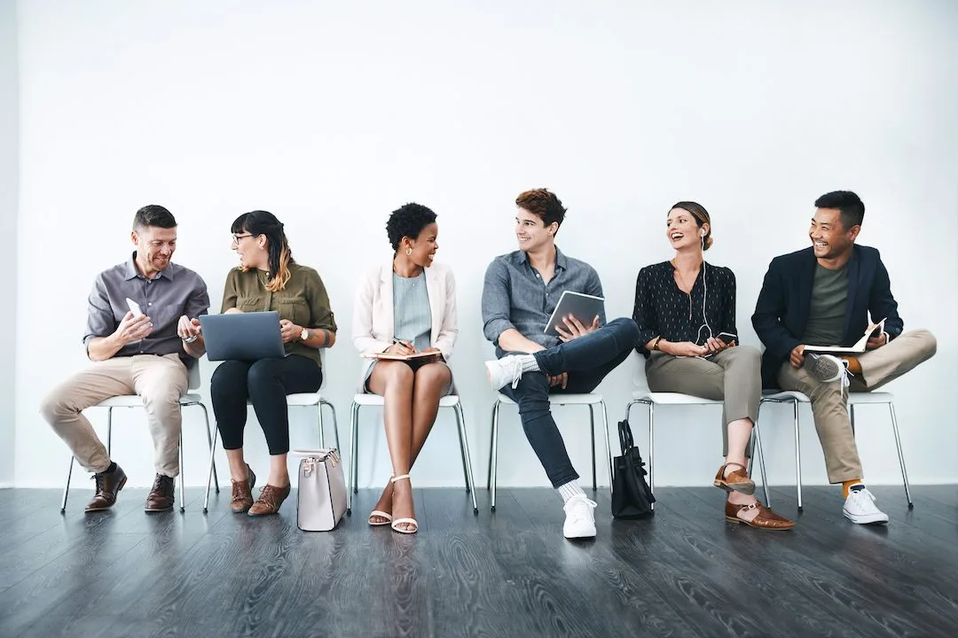 Image: Getty Images Group of business people chatting before interview