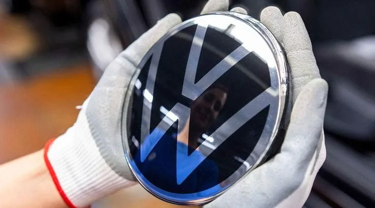 Image: Getty Images Gloved hands holding item with Volkswagen logo