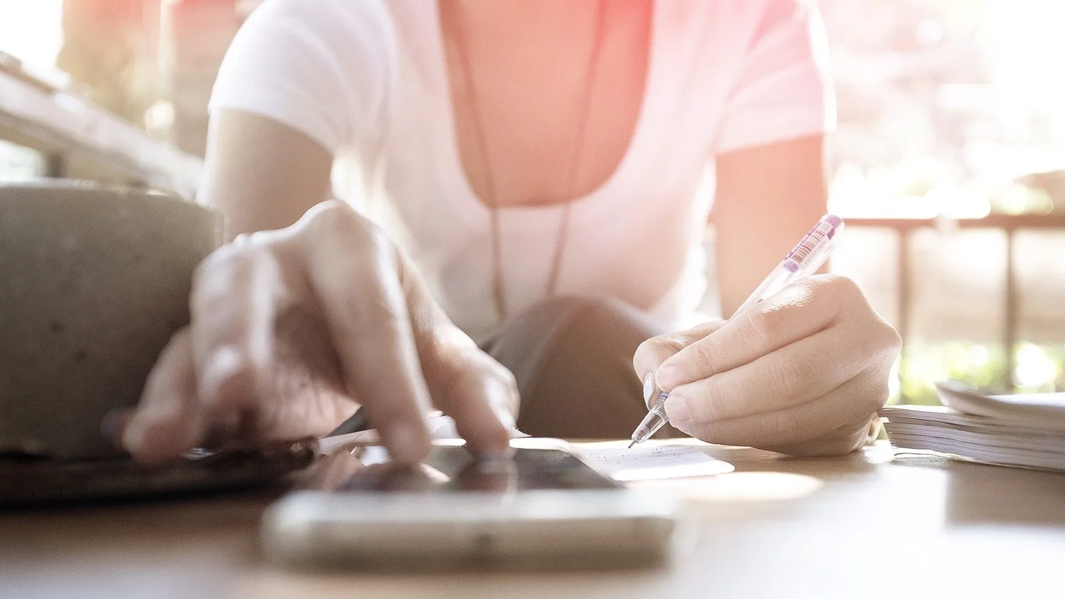 Image: Getty Images Woman Checking Mobile while Writing