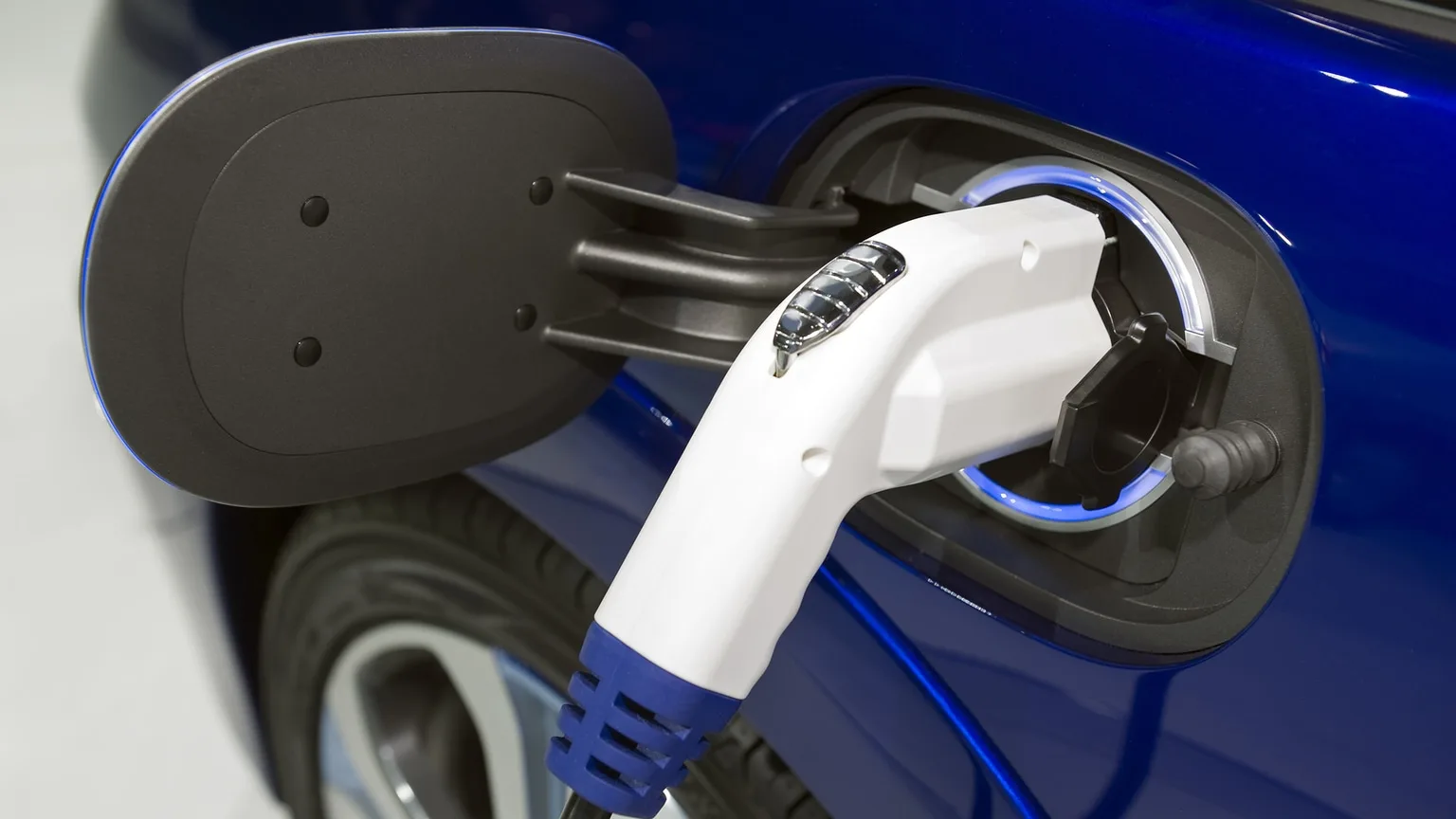 Image: Getty Images Closeup image of blue electric car being recharged
