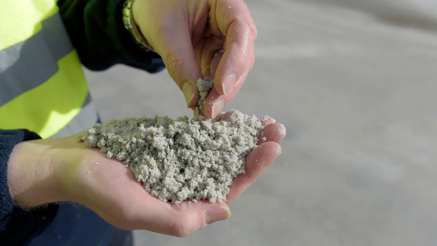 Image: Getty Images Close up of worker's hands holding processed lithium