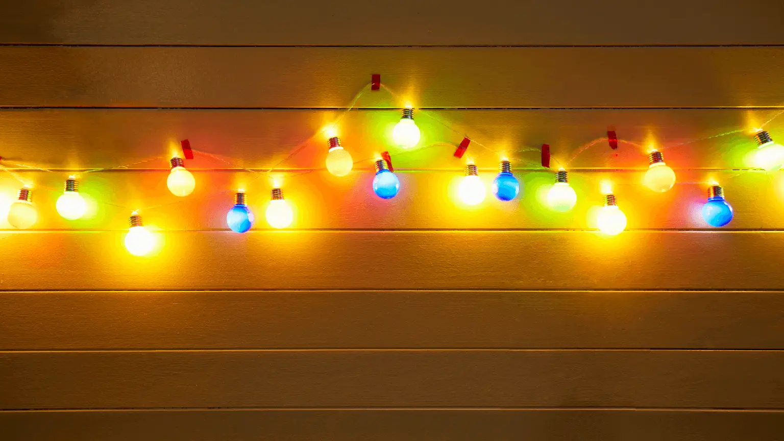 Image: Getty Images Illuminated colorful string lights for party decoration at a yellow painted wooden wall in the evening