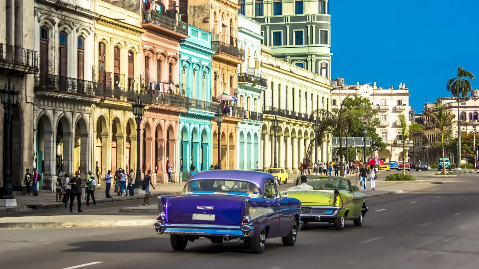 Image: Getty Images Vintage car driving down a sunny street in Cuba