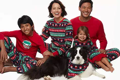 family and a dog wearing Christmas clothing matching each other